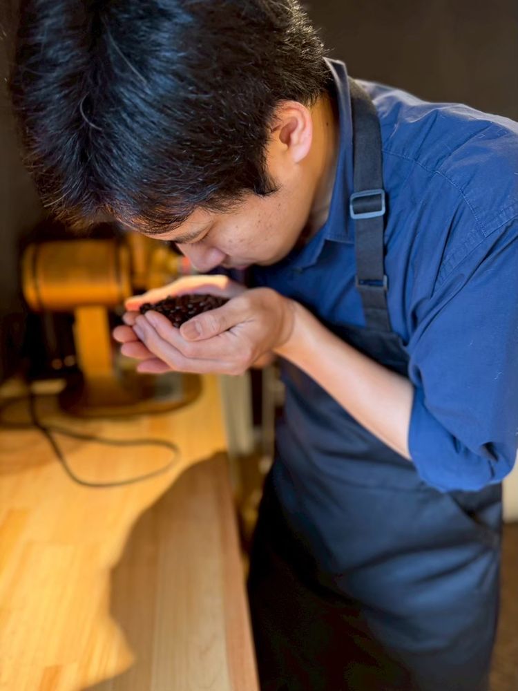 焙煎したての豆の香りを確かめる焙煎人